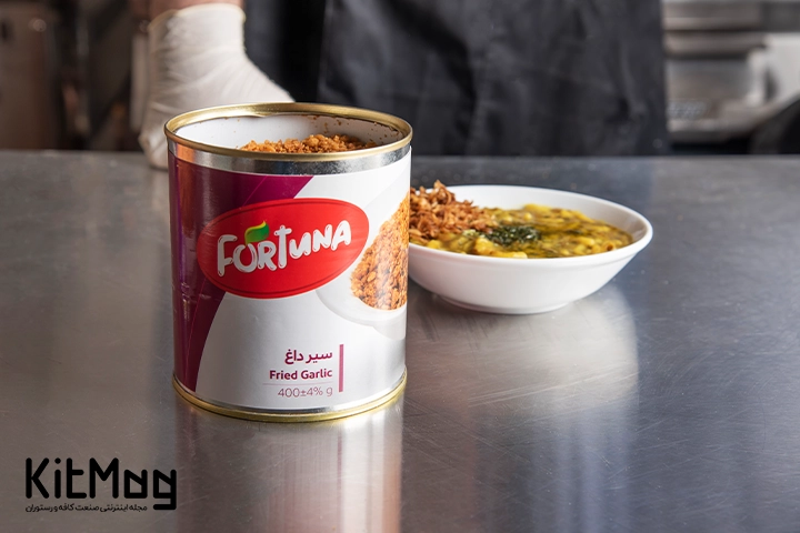 یک کنسرو سیر داغ که در کنار یک پیاله آش قرار گرفته است