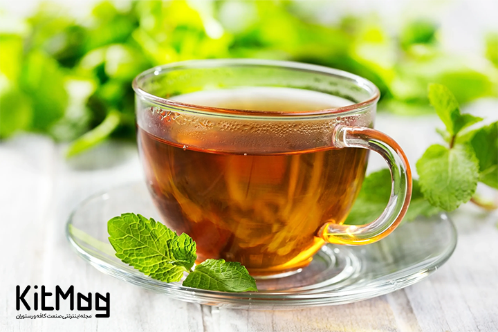 چای سبز در فنجان شیشه ای با دورچین برگ های نعنا