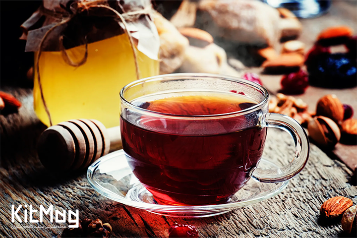 چای سیاه در فنجان شفاف شیشه ای با دورچین بادام و عسل