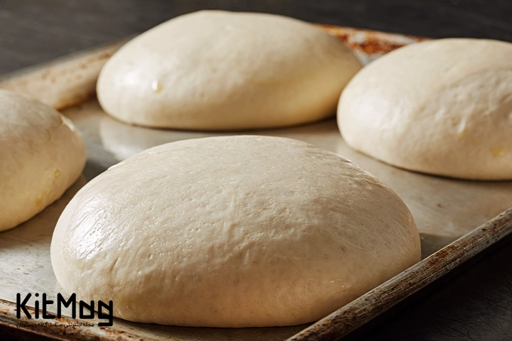 خمیر پیتزا ناپولیتن آماده برای پخت پیتزا که داخل یک سینی بزرگ قرار گرفته است