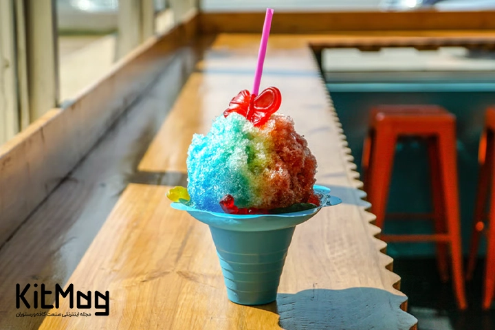 اسنو کان snow cone  با طعم های رنگارنگ در کنار هم داخل یک ظرف یکبار مصرف به همراه یک نی صورتی