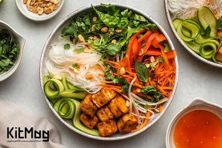 یک کاسه نودل ورمیشل که با خیار جوجه هویج جعفری و دیگر مواد غذایی تزئین شده است