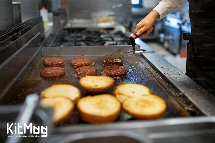 گریل تخت همبرگر که برگر ها به همراه نان برگر بان روی آن قرار گرفته است