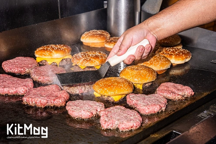 انواع همبرگر روی یک گریل تخت ذغالی در حال پخت برای سرو مشتری