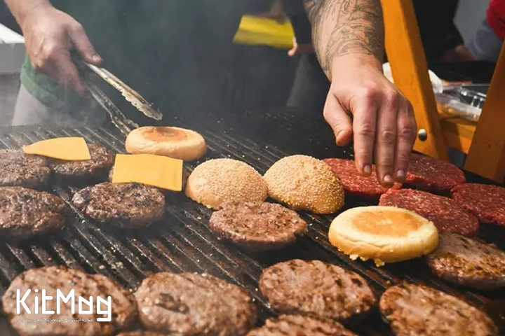 گریل برقی که آشپز در حال پخت برگر روی آن می باشد