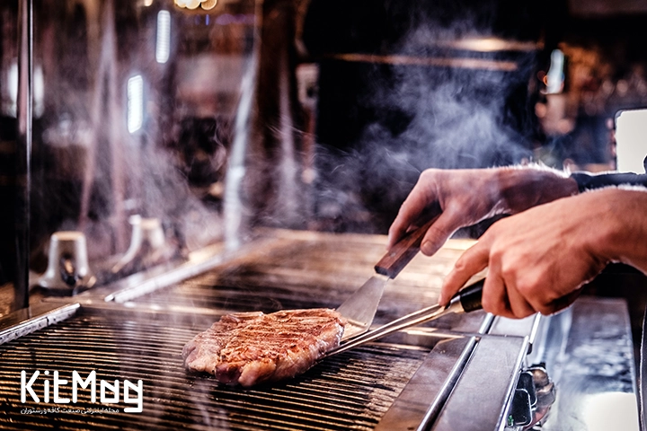 آشپز در حال آماده سازی گوشت برگر برای جلوگیری از چسبیدن گوشت برگر به گریل