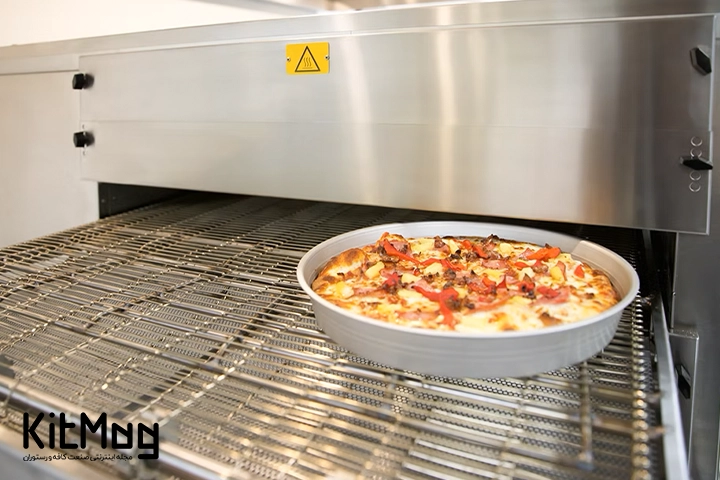 پیتزای آمریکایی که داخل قالب پیتزا قرار گرفته و پخته است و در حال خارج شدن از فر ریلی پیتزا می باشد