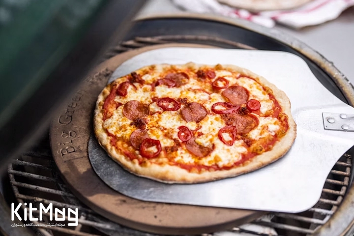 پیتزا آماده شده که از داخل فر بریک یا گنبدی پیتزا بیرون آورده شده است