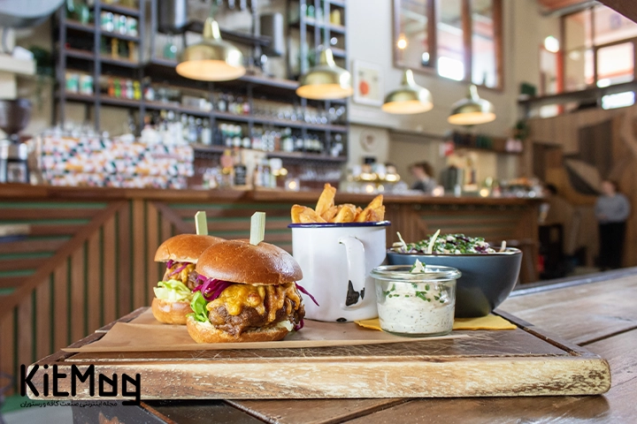 اشتباهات رایج در پخت همبرگر
دوعدد برگر روی میز رستوران قرار گرفته است و در کنار آن سس ماست یک کاسه سالاد و سیب زمینی داخل یک لیوان قرار گرفتته است