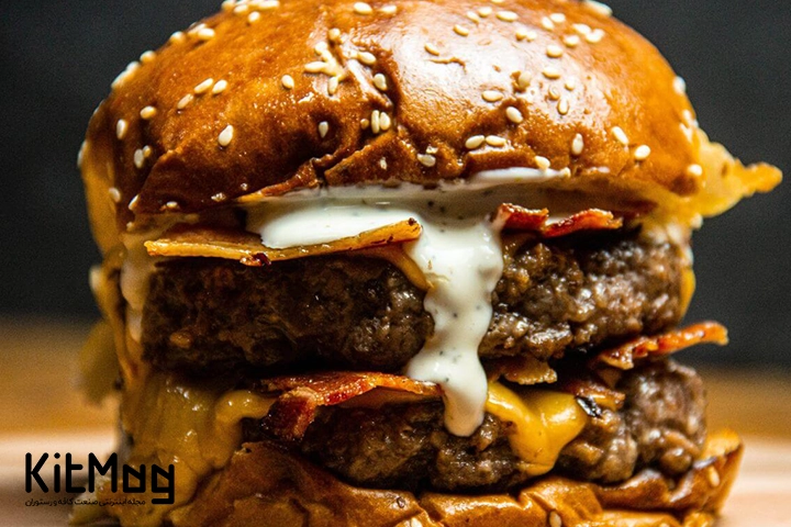همبرگر دبل برگر که با دولایه پنیر چدار پر شده است و لابه لای آن بیکن قرار گرفته است