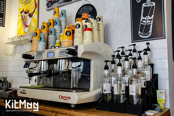 تفاوت سس تاپینگ و سیروپ در کافی شاپ
یک دستگاه نیمه اتوماتیک اسپرسو ساز که روی آن لیوان های یکبار مصرف قهوه قرار گرفته است و در کنار آن پمپ های غلیظ پاش سیروپ دیده می شود