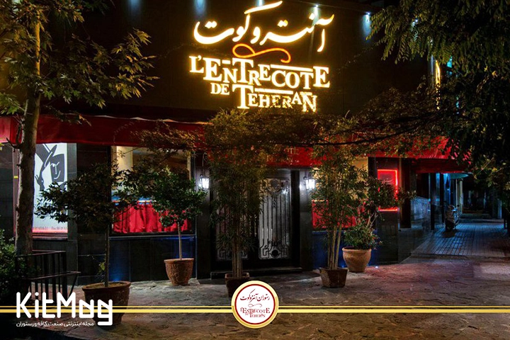 رستوران آنتروکوت در نمای شب که تابلوی آن از بیرون به فارسی و انگلیسی دیده میشود