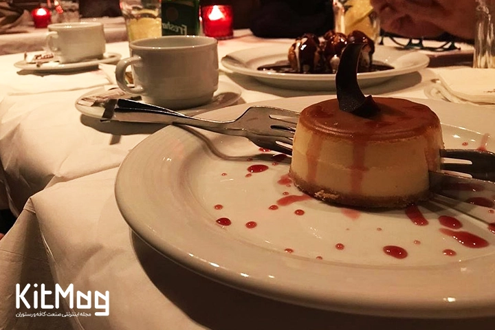 دسر کلاسیک و مخصوص رستوران آنتروکوت که با یک تکه شکلات مدل دار تزئین شده لایه روی آن کارامل است و زیر آن بیسکوییت مخصوص دیده می شود که داخل یک بشقاب با تزئین سیروپ آلبالو دیده میشود و در کنار آن چای و انواع بستنی در بشقاب دیده می شود