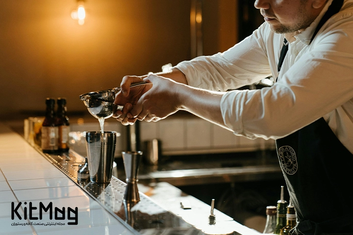 یک بارتندر که در حال عصاره گیری با جویسر یا Juicer یا همان آب مرکبات گیری یا عصاره گیر است