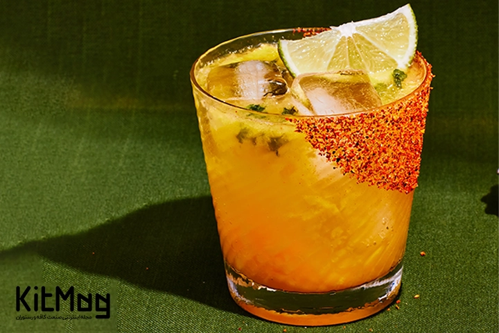 مانگو مانیا (Mango Mania Mocktail)
این موکتل خوشمزه داخل لیوان پایه کوتاه ریخته شده است و با لیمو یخ و نعنا تزئین شده است و روی یک صفحه عکاسی سبز قرار گرفته است