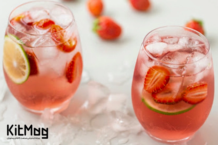 موکتل فیز لیموناد توت فرنگی (Strawberry Lemonade Fizz) که داخل لیوان های پایه کوتاه رستورانی ریخته شده است و داخل آن با تکه لیمو ترش و توت فرنگی با مقدار زیادی یخ تزئین شده است