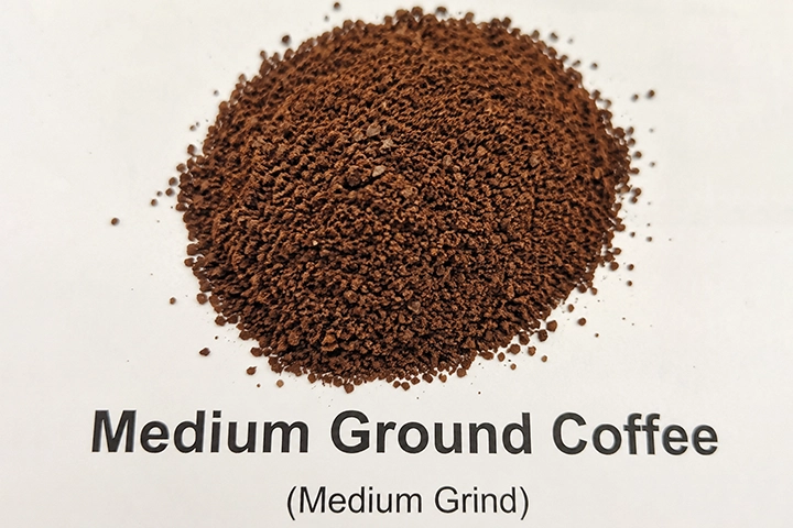آسیاب متوسط رو به ریز  (Medium-Fine Ground Coffee)
قهوه آسیاب شده مدیوم که دانه های آن روی میز ریخته شده است