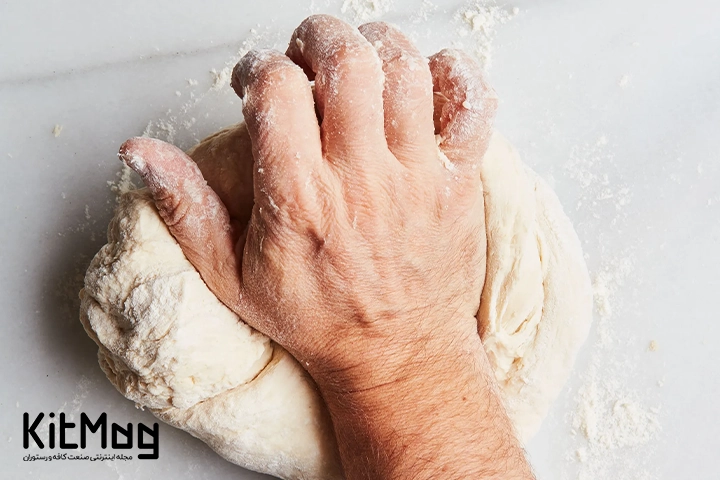 یک خمیر مخصوص پخت پیتزا که یک آشپز در حال ورز دادن آن با دست می باشد