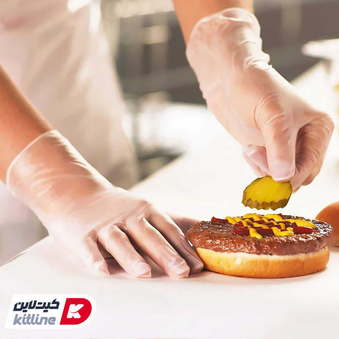کارگر رستوران در حال آماده سازی همبرگر با دستکش یکبار مصرف وینیل Medium